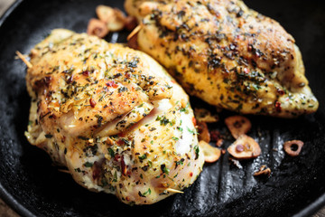 Two roasted chicken rolls lying on grill pan. Close up image