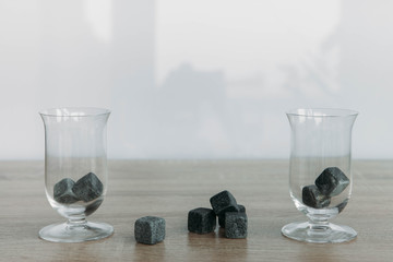 Stones for cooling whiskey and glases tulup on light wooden background