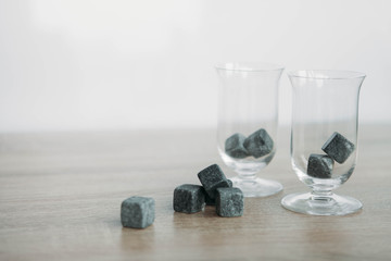 Stones for cooling whiskey and glases tulup on light wooden background