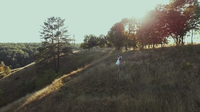 Attractive couple celebrate their wedding. Aerial view. Sunset.