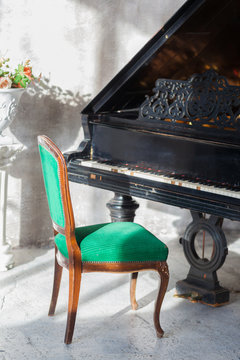 Black old piano and green vintage armchair