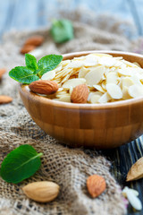 Almond flakes in bowl and a sprig of mint.