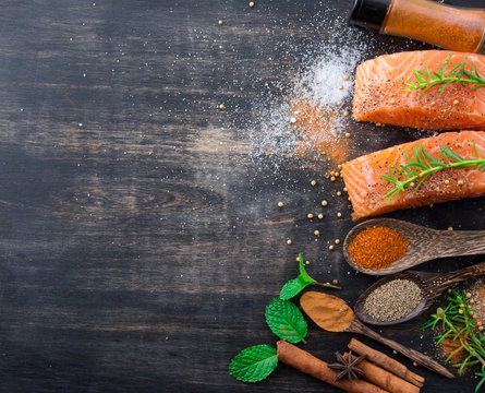 Raw salmon fish fillet with spoon herbs and spices on rustic wooden background,top view