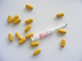 pills and medical dropper on white background