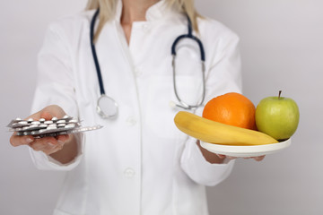 Health care and healthy eating, nutrition balance concept. Female Doctor holding medicine pills and apple