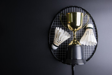 Golden trophy, Shuttlecocks and badminton racket on black background.Sport concept, Concept winner, Copy space image for your text.