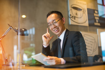 happy asian man using tablet