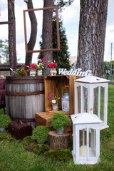 Fototapeta na wymiar Beautiful wedding ceremony outdoors. Decorated chairs stand on the grass. Wedding arch made flowers on a green natural background. Old doors, rustic style.