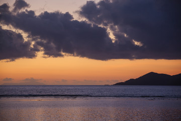 Fototapeta na wymiar Orange sunset in dark clouds above Indian ocean, Seychelles