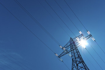 Strommast mit Sonne und Himmel