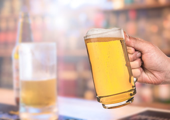  leisure and drinks concept , male hands clinking beer mugs at bar or pub