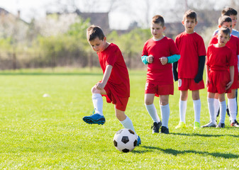 Kids soccer football - children players exercising before match on soccer field