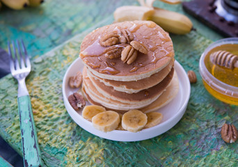 The American pancakes with honey, bananas and nuts
