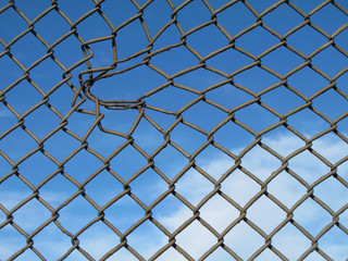 Naklejka premium .......verja metálica con agujero más ancho y fondo azul del cielo