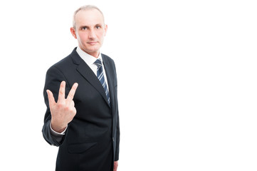 Portrait of aged elegant man showing number three gesture