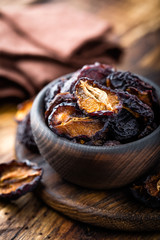 Prune, dried plums fruits on dark rustic wooden background