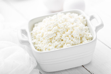 Cottage cheese on white wooden rustic background, dairy product