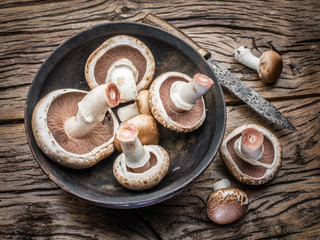 Champignon mushrooms on the wooden table.