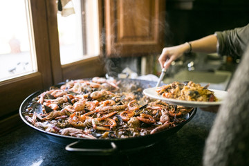 Photo with selective focus on the seafood of amazing homemade fresh artisanal Paella in grandmas...