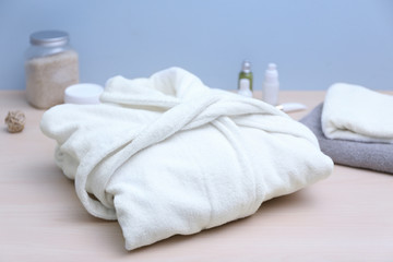 Folded spa bathrobe on table - obrazy, fototapety, plakaty
