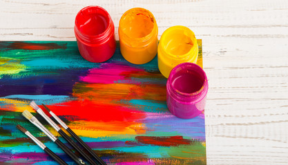 Artist's workshop.Items for children's creativity on a wooden background. Acrylic paint and brushes on white wooden background. Picture with copy space and for add text. some art stuff on wooden table