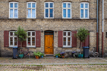 Vintage bicycles along old brick house with greenery