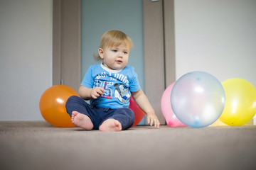 Fototapeta na wymiar baby playing with balloons at home