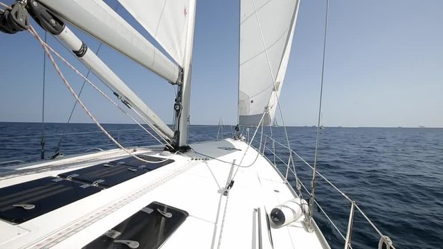 Many sailboats go under white sails on the blue sea around the island, clear blue sky, great warm summerday. Vacation, freedom and recreation concept. Active lifestyle.