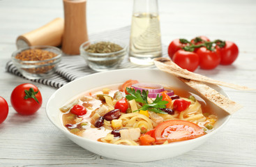 Chicken tortilla soup in plate on wooden table