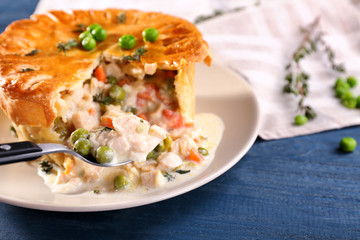 Tasty chicken pot pie with green peas on plate