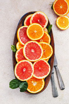 Variety  sliced citrus fruit orange, grapefruit, lemon on  wooden board. Top view.