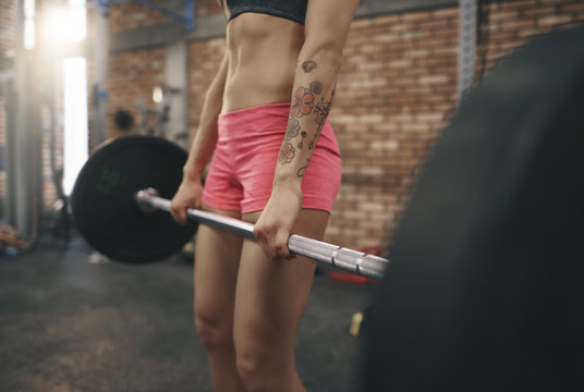 Female legs while lifting a barbell