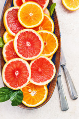 Variety  sliced citrus fruit orange, grapefruit, lemon on  wooden board. Top view.
