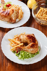 Roasted chicken legs with french fries and lettuce
