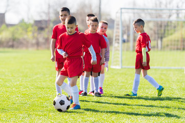 Obraz premium Kids soccer football - children players exercising before match on soccer field