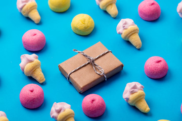 photo of tasty colorful marshmallows and cute gift on the wonderful blue background