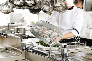 Chef in hotel or restaurant kitchen cooking
