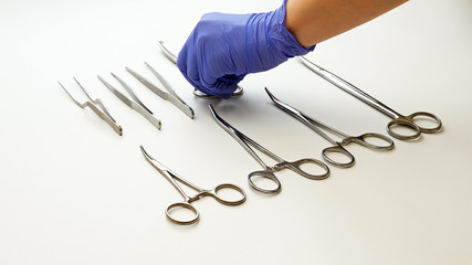 Surgical nurse in protective gloves prepares and puts medical surgery tools on table