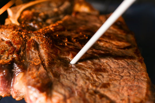 Tasty steak with thermometer, closeup