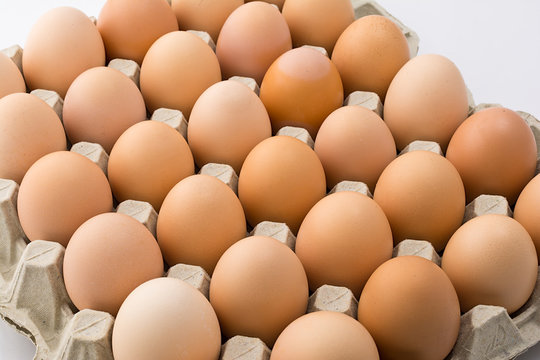 Background of chicken eggs in a cardboard tray.