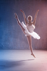 Young beautiful ballerina dancing in studio