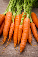 Fresh and sweet carrot on a grey wooden table.