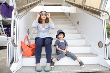 Young mother with her son sitting on the stairs