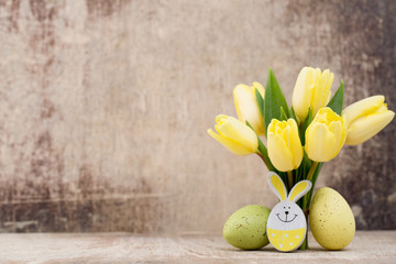 Spring decor, yellow tulips with easter eggs.