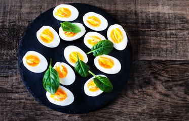 Halved Eggs on wooden background closeup..