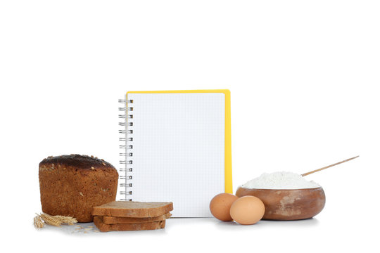 Open recipe book and bread on white background