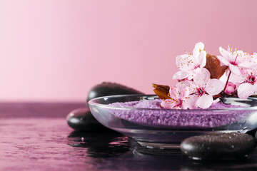 Obraz na płótnie Canvas Beautiful pink Spa Flowers on Spa Hot Stones on Water Wet Background. Side Composition. Copy Space. Spa Concept. Pink Background.
