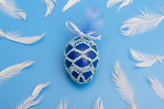 easter egg painted and dressed in feathers