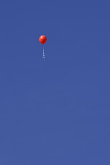 lonely red balloon in blue sky