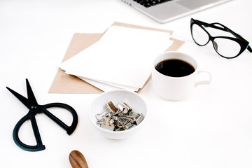Top view office table desk. Workspace with coffee, craft envelope, scissors, paper blank on white background.